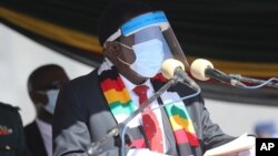 FILE - Zimbabwean President Emmerson Mnangagwa addresses mourners at the burial of Zimbabwean minister Perence Shiri, who died of Covid-19, during his burial in Harare, July, 31, 2020.