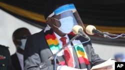 FILE - Zimbabwean President Emmerson Mnangagwa addresses mourners at the burial of Zimbabwean minister Perence Shiri, who died of Covid-19, during his burial in Harare, July, 31, 2020.