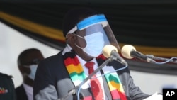 FILE - Zimbabwean President Emmerson Mnangagwa addresses mourners at the burial of Zimbabwean minister Perence Shiri, who died of Covid-19, during his burial in Harare, July, 31, 2020.
