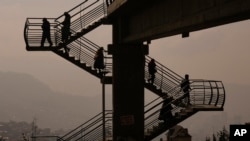 Pedestrians cross over a road as smoke from fires fills the air in La Paz, Bolivia.