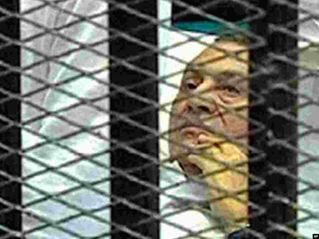 On August 3, 2011, Hosni Mubarak is in a Cairo courtroom lying on a hospital bed inside a cage of mesh and iron bars as his trial began. (AP/Egyptian State TV)