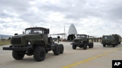 FILE - Military vehicles and equipment, parts of the S-400 air defense systems, are seen on the tarmac, after they were unloaded from a Russian transport aircraft, at Murted military airport in Ankara, July 12, 2019.