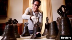 Estelle Ingrand-Varenne, researcher at the Centre de recherche francais a Jerusalem arranges bells from the 12th century that researchers say used to play music inside Bethlehem's Church of the Nativity. Picture taken December 14, 2021. (REUTERS/Amir Cohen)