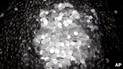 FILE - Unmarked 5-cent coins sit in a pile after being cut from a coil at the US Mint on June 27, 2012, in Philadelphia. 