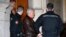FILE - Ilich Ramirez Sanchez, known as "Carlos the Jackal," is surrounded by French gendarmes as he leaves the Paris courthouse, March 3, 2014. 