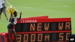 Ruth Jebet, de Bahreïn, pose à côté du tableau indiquant son record du monde dans l'épreuve féminine du 3000 mètres lors de la Ligue de diamant au Stade de France à Saint Denis, le 27 août 2016.