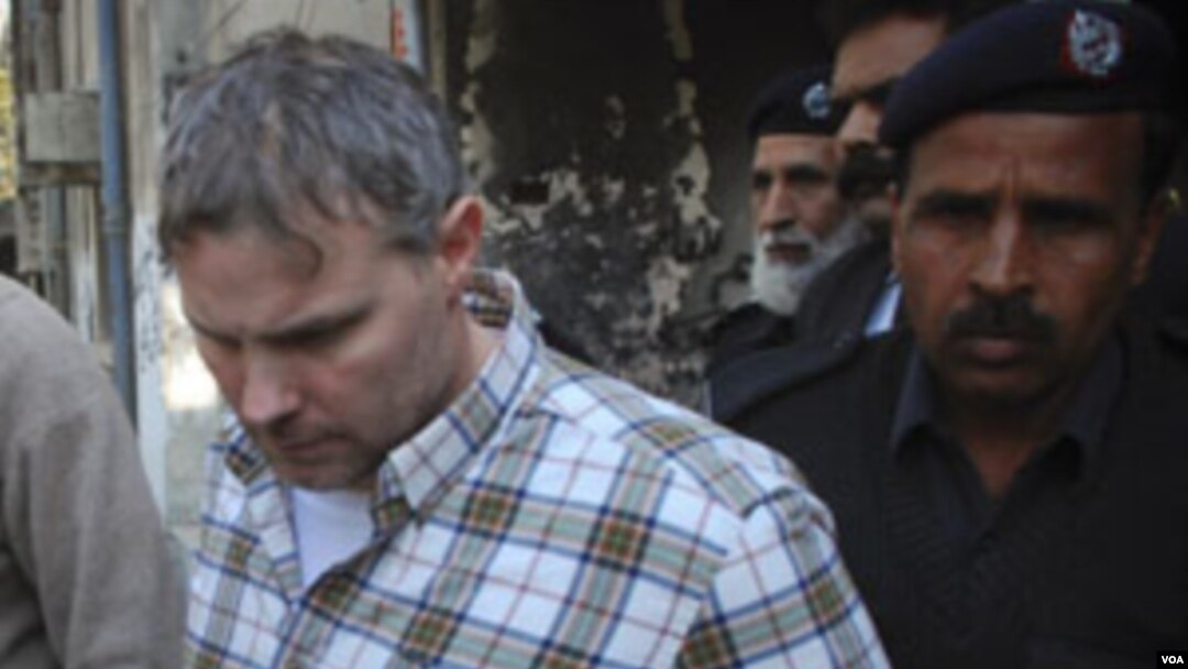 Polisi dan petugas pengadilan Lahore mengawal diplomat AS, Raymond Davis, keluar dari ruang persidangan setelah Davis menghadap hakim (1/28).
