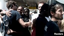 Des migrants débarquent du navire de sauvetage Aquarius après leur arrivée au port de Valence, en Espagne, le 17 juin 2018. (Kenny Karpov/SOS Mediterranee/Handout via Reuters)