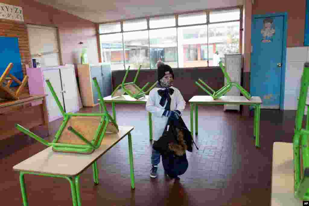 A student enters his public school classroom for the first time in three months since the lockdown to curb the spread of the new coronavirus pandemic in Montevideo, Uruguay.