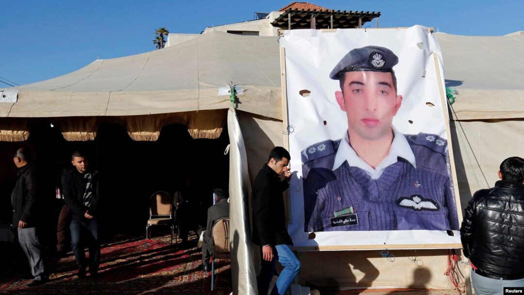Kerabat dari pilot Yordania, Muath al-Kasaesbeh, yang ditawan ISIS, memasang poster pilot tersebut di Amman. 