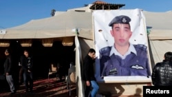 Kerabat dari pilot Yordania, Muath al-Kasaesbeh, yang ditawan ISIS, memasang poster pilot tersebut di Amman. 