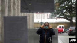 A man puts a face mask on as he arrives at a health center in Vigo, northwestern Spain, on January 10, 2024.