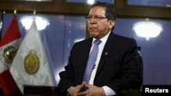 A Kashmiri boy shields himself with plywood from stones and glass marbles during a clash between Indian policemen and protesters during a protest in Srinagar, Indian controlled Kashmir.