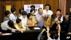 Anggota parlemen Taiwan terlibat pertikaian di podium legislatif sebelum dimulainya sesi sidang yang ditujukan untuk debat terkait kesepakatan terbaru perjanjian perdagangan Taiwan-China, di Taipei, Taiwan (29/7).