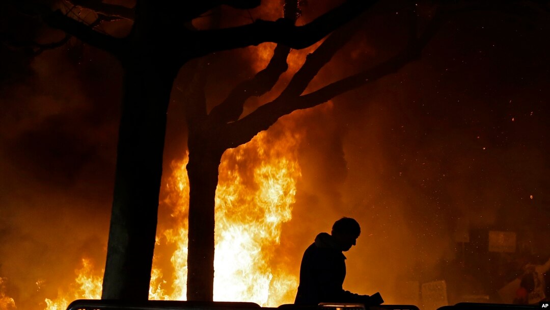 FILE - A fire set by demonstrators protesting a scheduled speaking appearance by Breitbart News editor Milo Yiannopoulos burns on Sproul Plaza on the University of California, Berkeley campus, Feb. 1, 2017.