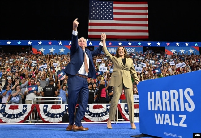 FILE - Minnesota Governor and Democratic vice presidential candidate Tim Walz (L) gestures alongside US Vice President and Democratic presidential candidate Kamala Harris at Desert Diamond Arena in Glendale, Arizona, on August 9, 2024. (Photo by Robyn Beck / AFP)