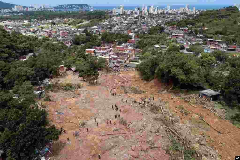 Rescue workers, residents, and volunteers search for victims after a mudslide caused by heavy rains in the coastal city of Guaruja, Brazil.
