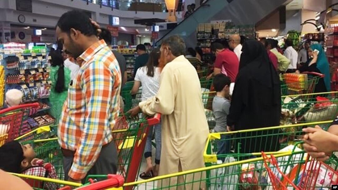 People are seen buying essential food staples at a supermarket in Doha, Qatar, Monday, June 5, 2017. Fears about food shortages came after some Gulf nations ended diplomatic relations with Qatar.