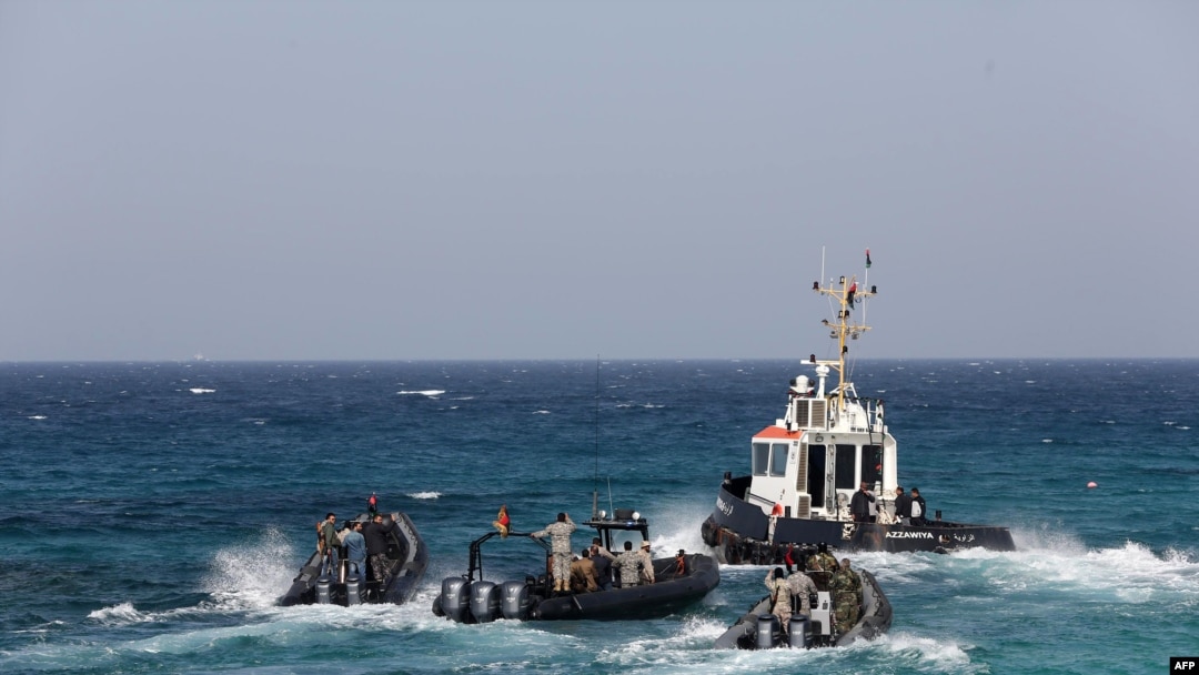 Para penjaga pantai Libya menunggu kedatangan kapal tanker Morning Glory (22/3) di pelabuhan Zawiya, Libya.