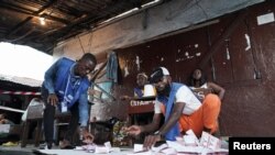 FILE —National Elections Commission (NEC) officials count ballots at a polling station during a runoff election between President George Weah and former Vice President Joseph Boakai in Monrovia, Liberia November 14, 2023.