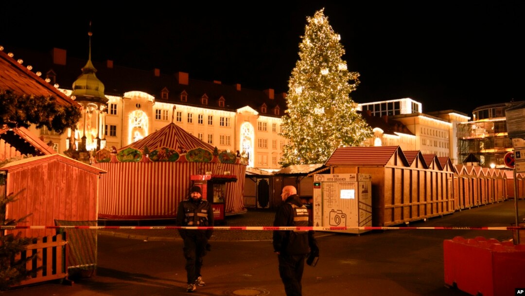 Security guards stand in front of a cordoned-off Christmas Market after a car crashed into a crowd of people, in Magdeburg, Germany, on Dec. 20, 2024.