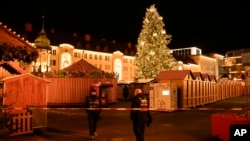 Security guards stand in front of a cordoned-off Christmas Market after a car crashed into a crowd of people, in Magdeburg, Germany, on Dec. 20, 2024.