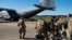 This Oct. 29, 2018 photo provided by the U.S. Air Force shows deployers from Headquarters Company, 89th Military Police Brigade, Task Force Griffin getting ready to board a C-130J Super Hercules from Little Rock, Arkansas, at Fort Knox, Kentucky.