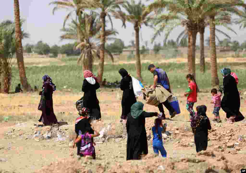 Displaced civilians from Ramadi and surrounding areas walk through Amiriyat al-Fallujah towards Baghdad, May 22, 2015.