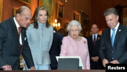 From left, Prince Phillip, Maria Clemencia Rodriguez de Santos, Queen Elizabeth and President Juan Manuel Santos look at Colombian items from the Royal collection in the picture Gallery of Buckingham Palace, November 1, 2016. 
