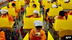 지난달 29일 타이완 타이페이의 다지아 초등학교에서 학생들이 책상에 칸막이를 두른 채 점심식사를 하고 있다. 