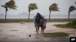 Une femme et son enfant se protège du vent dans une couverture, à Caibarien, Cuba, le 8 septembre 2017.