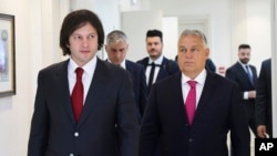 In this photo provided by the Georgian Prime Minister Press Office on Oct. 29, 2024, Georgian Prime Minister Irakli Kobakhidze, left, and Hungarian Prime Minister Viktor Orban walk during their meeting in Tbilisi, Georgia.