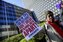 FOTO DE ARCHIVO: Una mujer sostiene un cartel mientras inmigrantes haitianos y simpatizantes se manifiestan para rechazar la decisión del DHS de terminar el TPS para los haitianos, en el distrito de Manhattan en Nueva York.