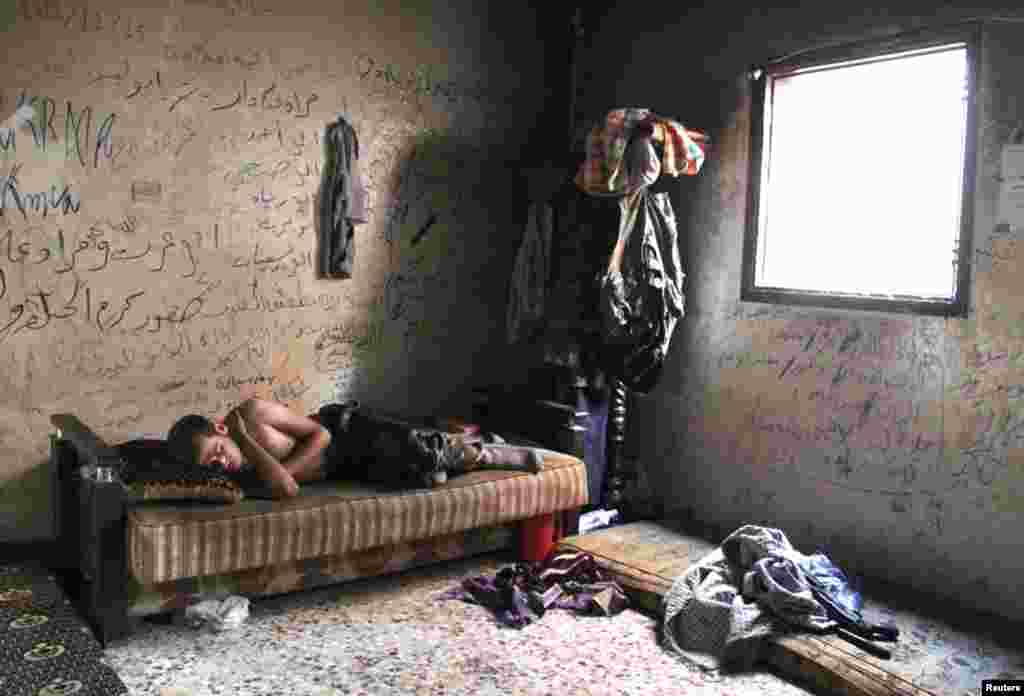 A Free Syrian Army fighter rests inside a house in Aleppo's Karm al-Jabal district August 6, 2013.