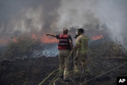اسرائیل میں فائر فائٹرز حزب اللہ کے راکٹوں سے سرحدی علاقے میں بھڑکنے والی آگ کو بجھانے کی کوشش کررہے ہیں۔ 4 جولائی 2024