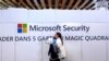FILE - A woman walks in front of the Microsoft stand during a cybersecurity conference in Lille, France, Jan. 29, 2020. 
