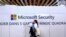 FILE - A woman walks in front of the Microsoft stand during a cybersecurity conference in Lille, France, Jan. 29, 2020. 