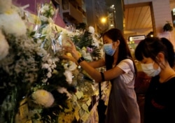 Women pay their respects to the protesters who were injured during clashes with the police by placing flowers outside Prince Edward station, in Hong Kong, Sept. 4, 2019.