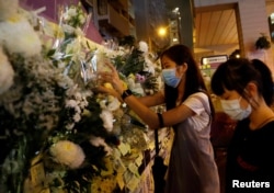Women pay their respects to the protesters who were injured during clashes with the police by placing flowers outside Prince Edward station, in Hong Kong, Sept. 4, 2019.