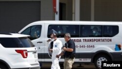 Un secouriste portant un équipement de protection à l'extérieur du terminal passagers où le navire Coral Princess, de la flotte Princess Cruises, avec des patients affectés par COVID-19, est amarré au port de Miami, Floride, États-Unis, le 4 avril 2020. REUTERS / Marco Bello