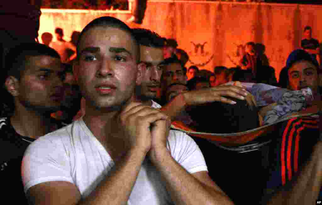 Palestinians carry the body of Yosuf abu Zaghah who was killed by Israeli troops in the West Bank refugee camp of Jenin, July 1, 2014.