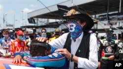 El piloto de NASCAR, Bubba Wallace, es consolado por el dueño de su equipo, Richard Petty, luego que sus compañeros de parrilla, en un acto de solidaridad, empujaran su auto hasta dejarlo al frente a la salida. Wallace se conmovió hasta las lágrimas.