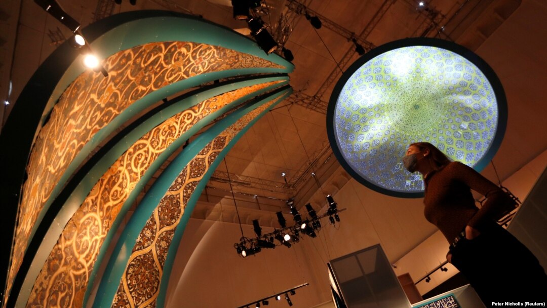 Seorang pegawai museum V&A melihat Dome Prejection dan lukisan-lukisan segitiga yang menggambarkan interior kubah masjid dalam pameran Epic Iran yang akan segera dibuka di London, Inggris, 25 Mei 2021. (Foto: Peter Nicholls/Reuters)