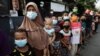 Sejumlah warga antre menerima bantuan dari Presiden Joko Widodo di tengah pandemi COVID-19 di Jakarta, Jumat, 16 Juli 2021. (Foto: Willy Kurniawan/Reuters)