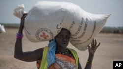 A woman walks back to her home after receiving food distributed by the Red Cross in South Sudan, April 11, 2017.