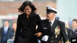 First lady Michelle Obama is escorted by USS Illinois Chief of the Boat, Master Chief David DiPietro during a commissioning ceremony for the U.S. Navy attack submarine USS Illinois, in Groton, Conn., Oct. 29, 2016. The submarine is named for Obama's home 