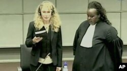 Actress Mia Farrow, left, is seen holding the bible being sworn on a screen in the pressroom of the U.N.-backed Special Court for Sierra Leone in Leidschendam, Netherlands, 09 Aug 2010