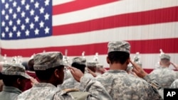 Soldiers salute the U.S. flag during a welcome home ceremony for soldiers at Fort Carson, Colo., Dec. 5, 2012. A Fort Carson soldier has been charged with killing his wife.
