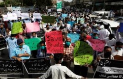 Teachers of private schools wear protective masks as they hold signs during a protest demanding the opening of schools, which are closed because of the spread of COVID-19, in Karachi, Pakistan June 10, 2020.