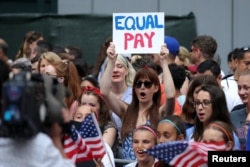 FILE - Women chant for equal pay for women as they wait for the United States women's national soccer team in New York City, July 10, 2019.